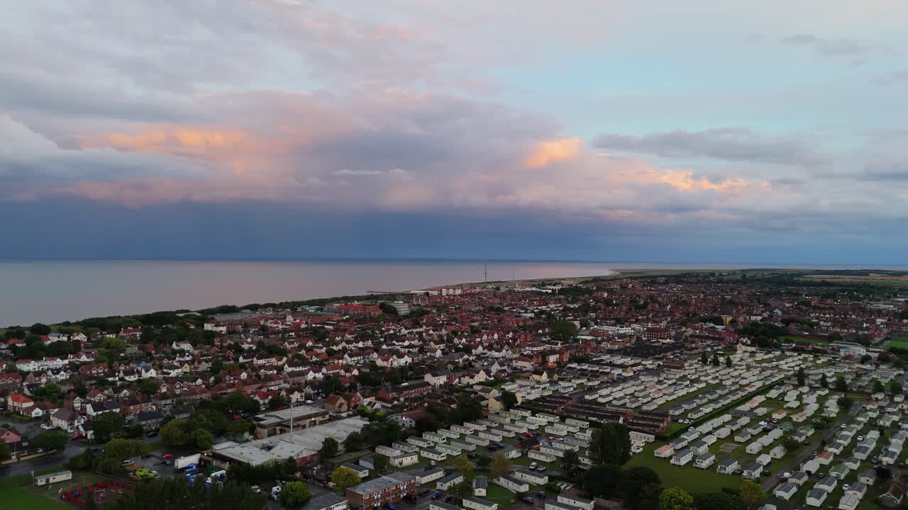 Coastal panorama of the town of Skegness with looming storm clouds over the North Sea. Seaside scene with rooftops at sunset