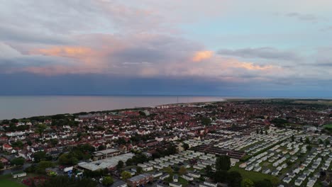 coastal panorama of the town of skegness with looming storm clouds over the north sea. seaside scene with rooftops at sunset