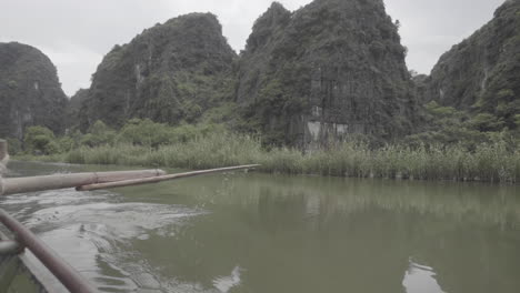 paddle boat cruising on the river in between the rice fields of vietnam in slowmotion on a cloudy day log