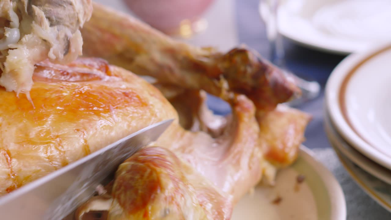Turkey Leg Being Cut Off and Put on Plate by Chef. Dinner Being Served to Guests at Thanksgiving or Christmas.