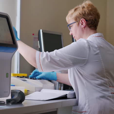 woman in medical uniform working with blood samples. modern equipment for testing sample analysis in the laboratory. medical concept.