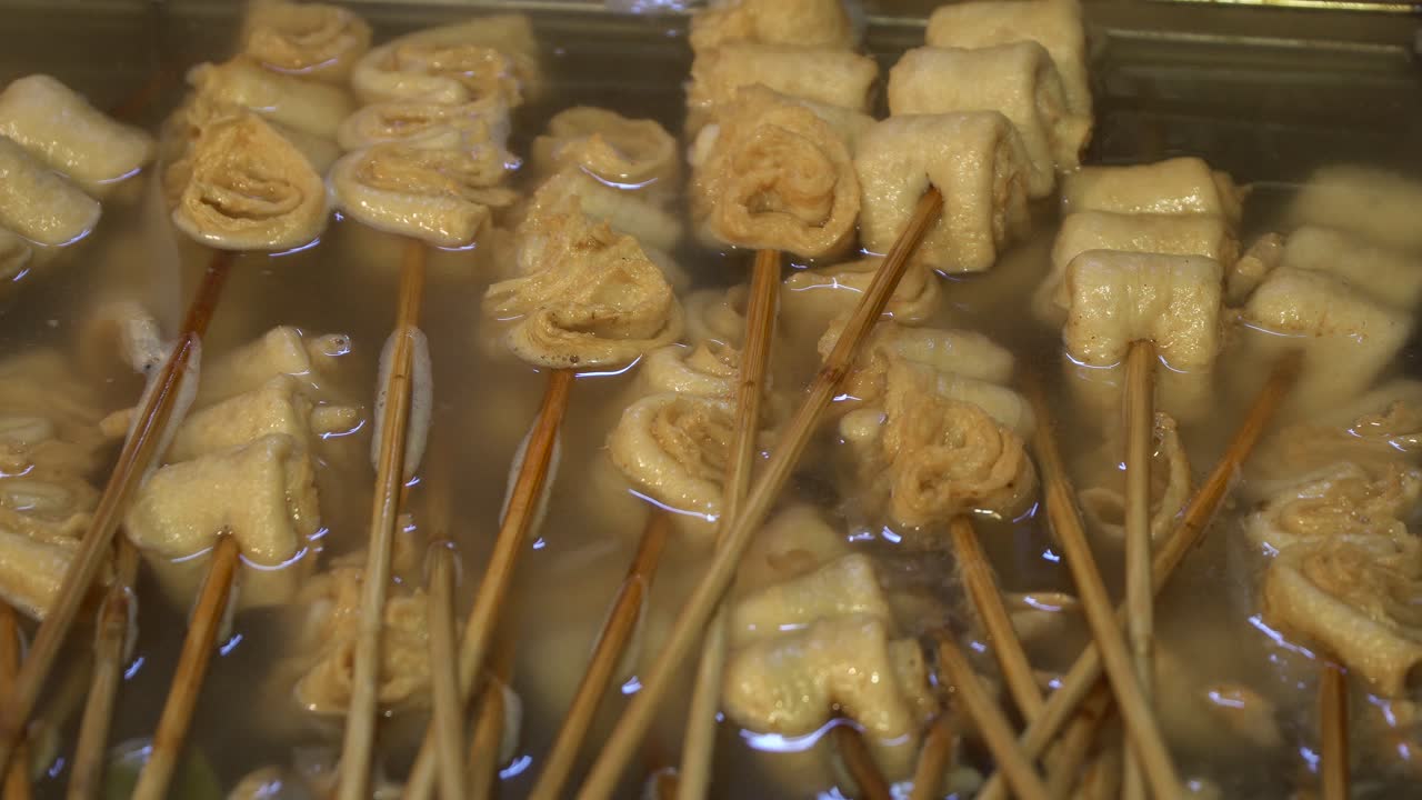 Oden nature blanc sur des brochettes en bois bouillant dans une soupe salée.