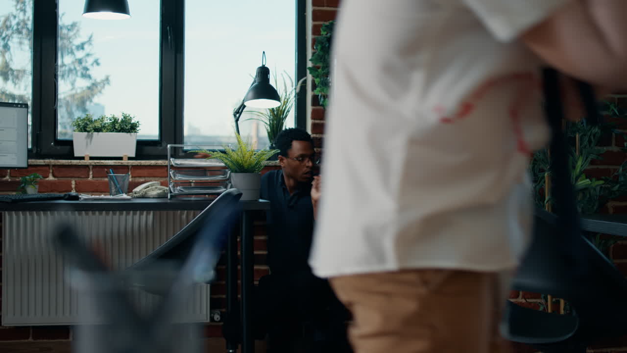 Shocked african american man hiding from mindless creepy zombies in office