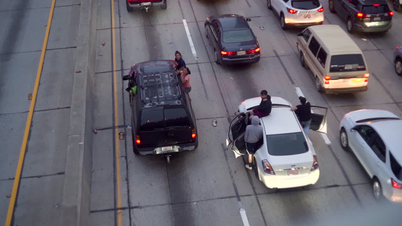 People stuck in traffic sit on top of their cars.