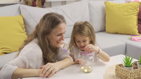 The-girl-with-the-piggy-bank.-The-boy-puts-money-into-the-piggy-bank.