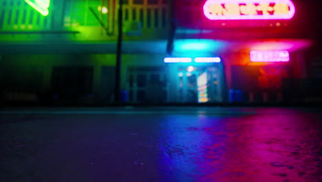 neon lights reflecting on wet pavement in a city at night