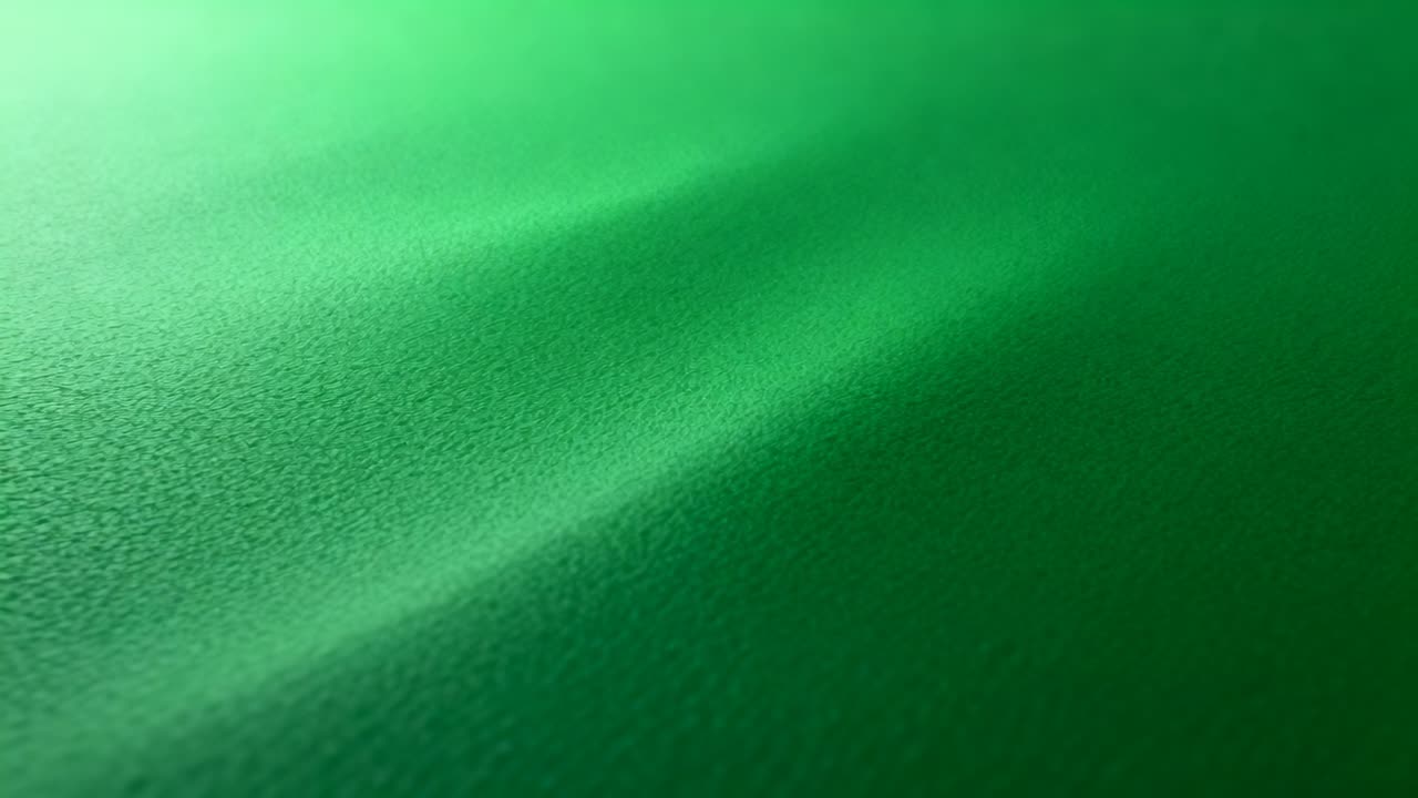 Shifting top-left light and focus revealing green felt texture on tabletop with diagonal ridge