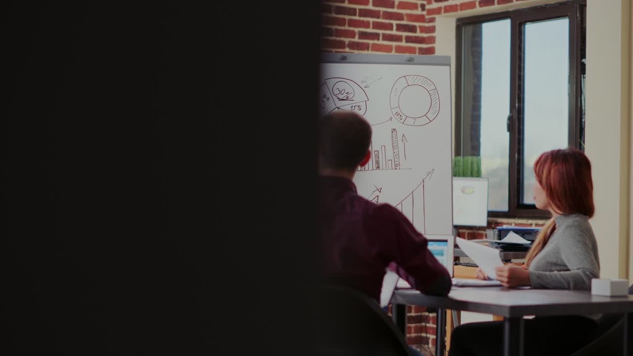 Diverse team of colleagues listening to business presentation