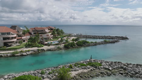 A-beautiful-aerial-view-of-a-beachfront-house,-perched-above-the-Caribbean-Sea