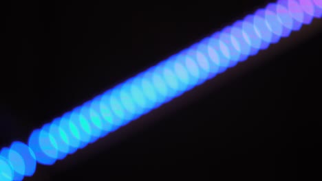 bokeh shot of defocused blurred christmas tree light that is blinking on black