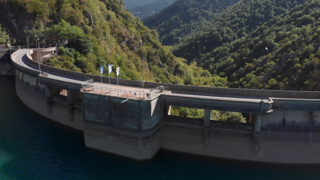 Curved hydro electric dam with road on top lake Plastiras Greece sunny