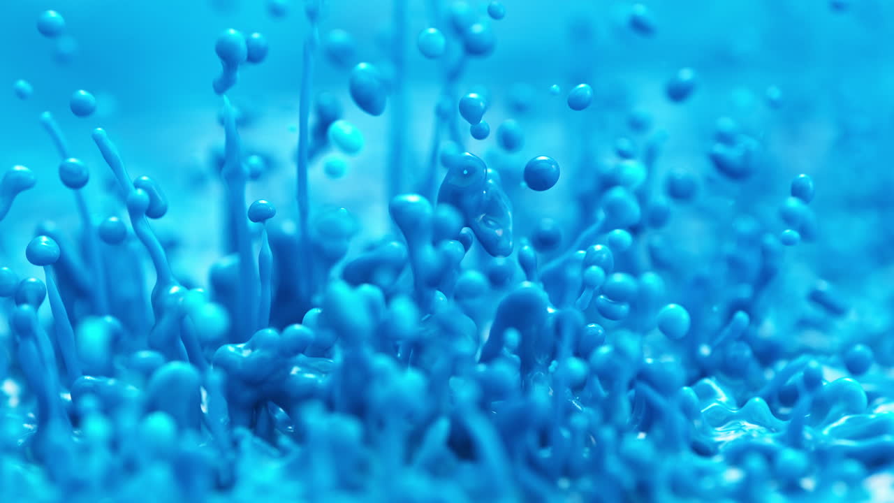 파란색 페인트는 느린 동작으로 어지고 방울을 만들어 니다. 거시적으로 추상적인 염색 된 액체입니다.