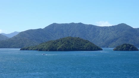 boats appear small against beautiful deep-blue sea and islands - karaka point, queen charlotte sound