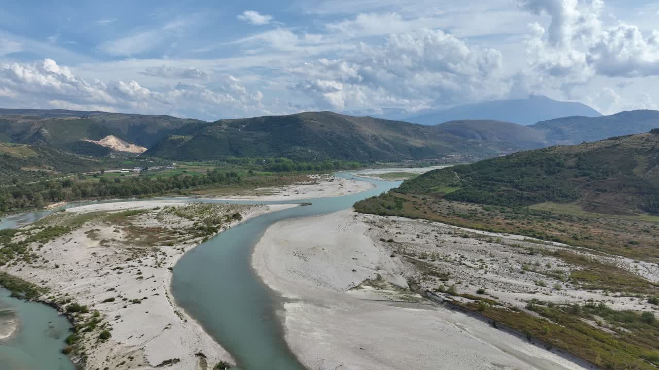 Albanian national park with massive mountains and a nearly dry river cutting through the valley.