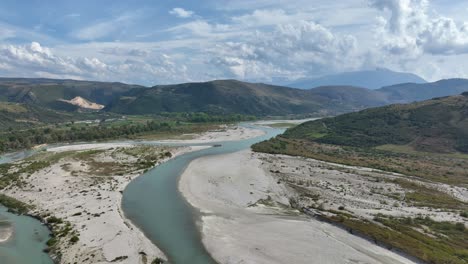 albanian national park with massive mountains and a nearly dry river cutting through the valley.