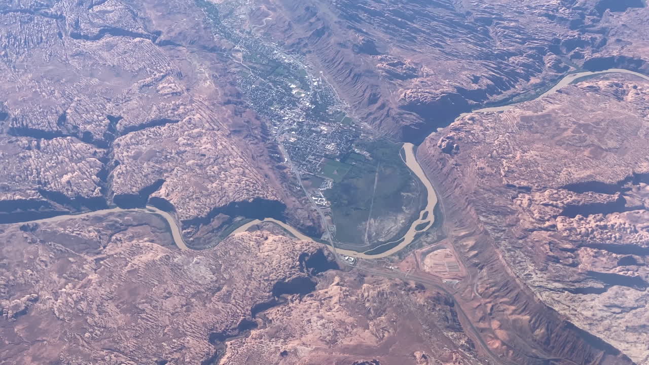 A tilting down aerial view of Moab, Utah as seen from cruising altitude of an airliner