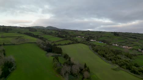 una perspectiva aérea giratoria revela los paisajes en cascada de las azores, portugal, que muestran actividades agrícolas