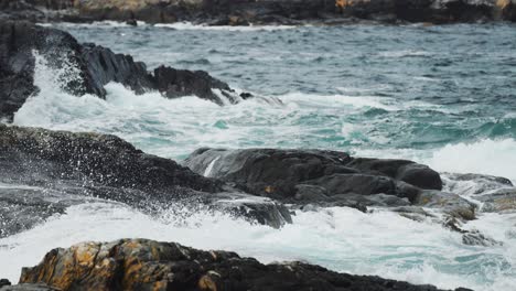 waves crash against the withered jagged rocky coastline near the atlantic road