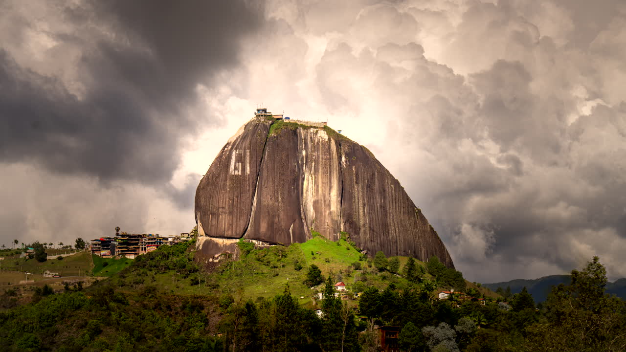Kolombiya, Guatapé yakınlarındaki El Peñón de Guatapé (La Piedra del Peñol)'un, dramatik fırtına bulutlarının ikonik granit monolitin yanından değişen ışıkta hızla geçerken çekilen sinematik hızlandırılmış çekimi.