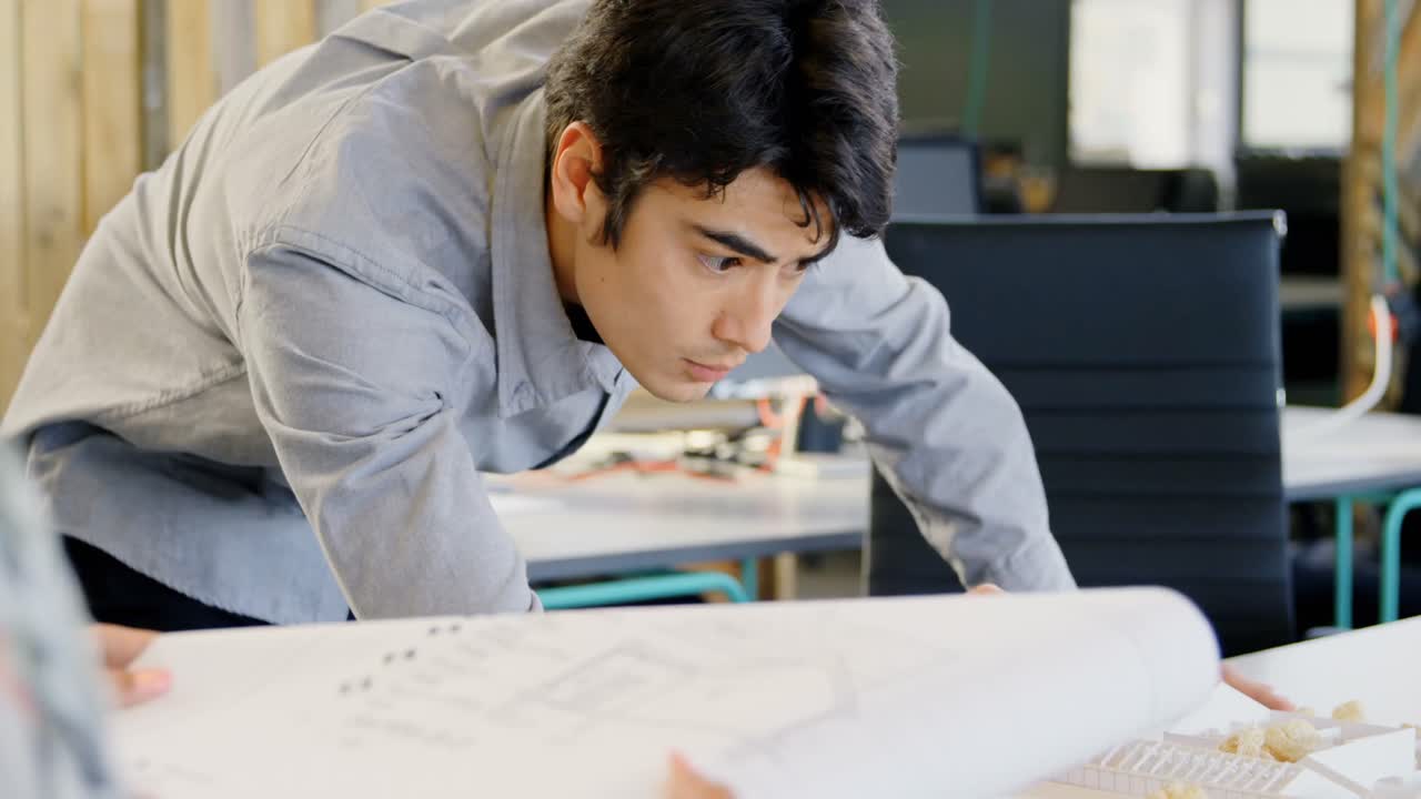 Executive working on architectural model in the office 4k