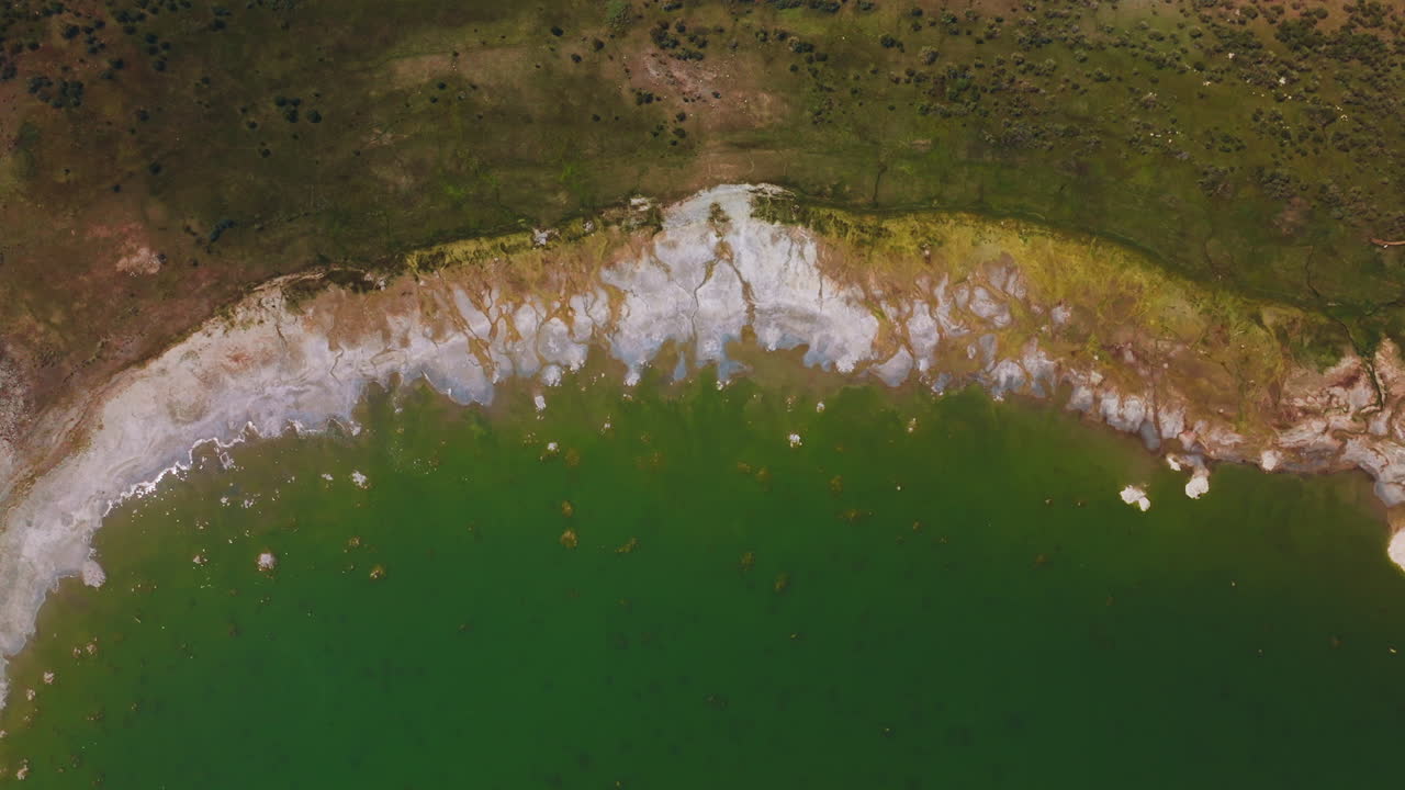 Salt at the waterfront of beautiful aquamarine waters. Circling over the bare shore of Mono Lake, California, USA at daytime.