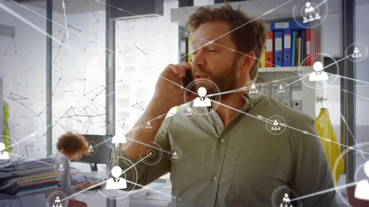 animación de la red de iconos de perfil contra el hombre caucásico hablando en el teléfono inteligente en la oficina.