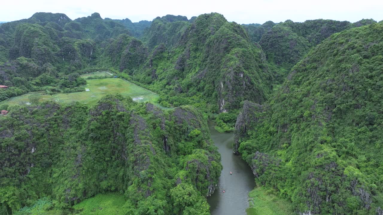 Aerial view of lush green karst hills and calm river in Ha Long Bay, Vietnam