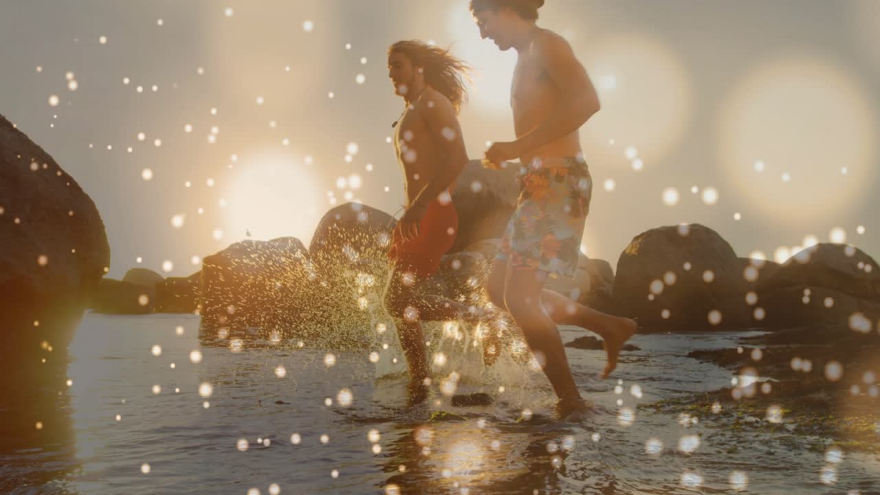 Two friends stepping off rock into shallow tidal water and running along sunset beach for fitness