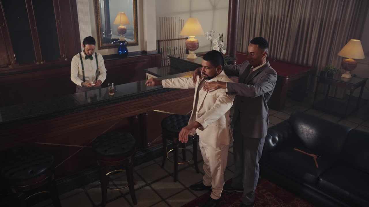 Men in suits socializing and embracing in an elegant bar
