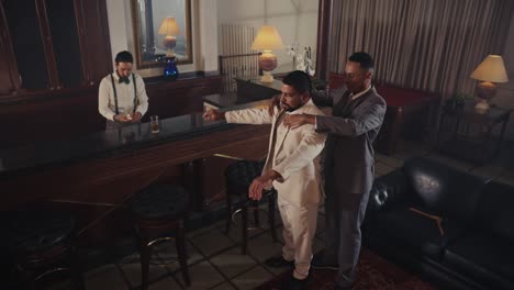 men in suits socializing and embracing in an elegant bar