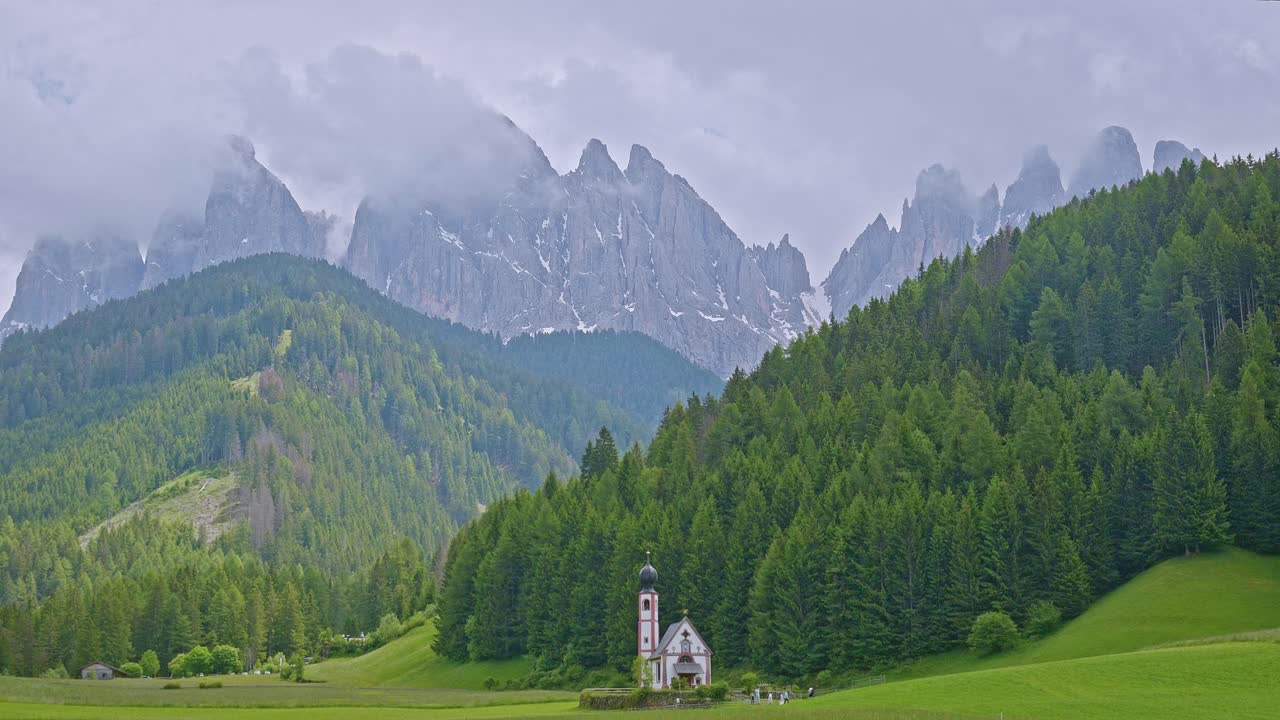 Chiesa di San Giovanni with mountain backdrop in green Alpine valley