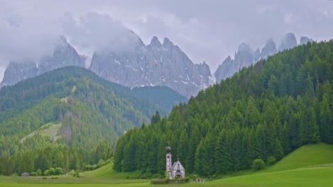 chiesa di san giovanni with mountain backdrop in green alpine valley