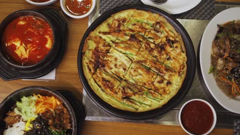 variety of korean cuisine-big plate of japchae, buchimgae, dakgaejang, bibimbap, and samgyeopsal in korean restaurant