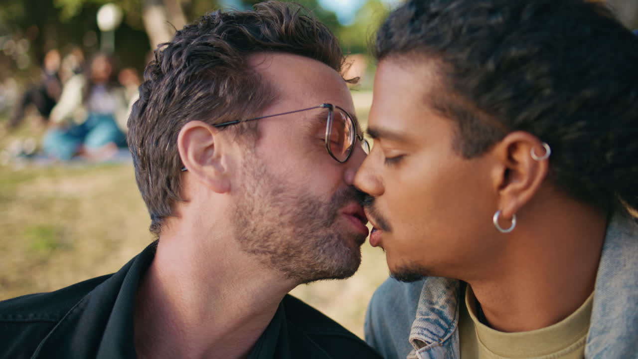 두 남자가 공원에서 키스하고 있다.