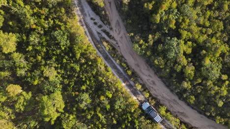 Clip-Aéreo-De-Un-4x4-Conduciendo-Lentamente-En-El-Remoto-Interior-De-Australia,-Al-Final-De-La-Tarde-En-Una-Pista-Forestal,-Clip-Uno