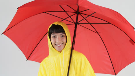 Woman-in-yellow-raincoat-holding-an-umbrella-4k