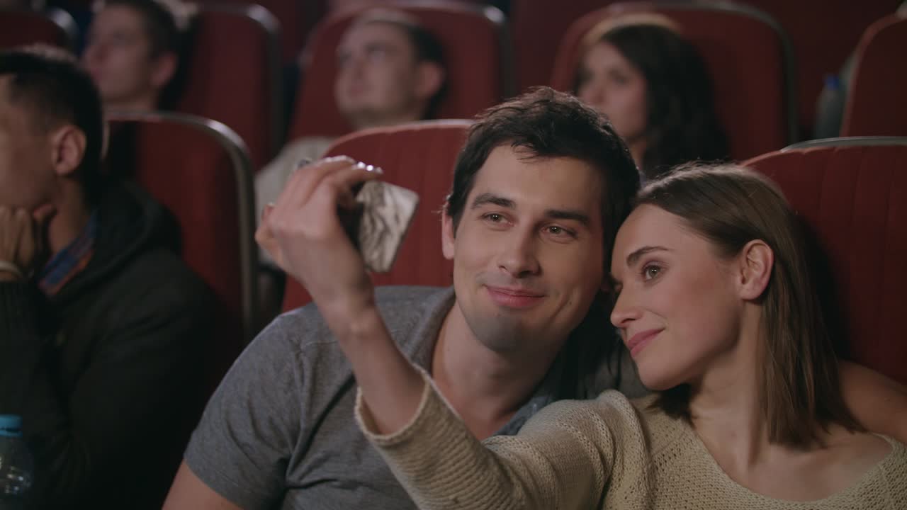 beso selfie en el cine. pareja feliz haciendo selfie en el cine