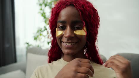 a woman with dark skin uses eye golden patches against wrinkles, feel relaxed