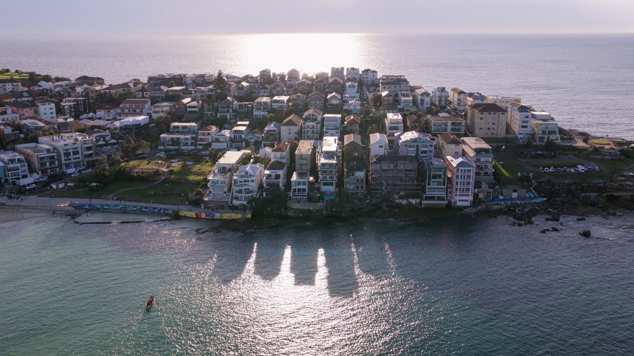 Epický letecký záběr při východu slunce nad Ben Buckler Point, luxusní čtvrtí s moderními domy a bytovými budovami na malebném poloostrově na severu Bondi Beach v Sydney, Austrálie