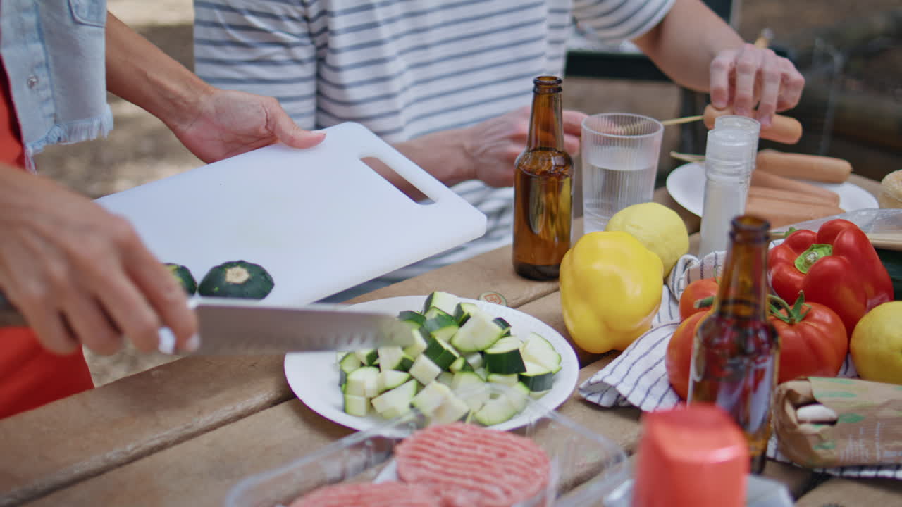 Closeup hands preparing vegetables at summer picnic forest. Unknown woman
