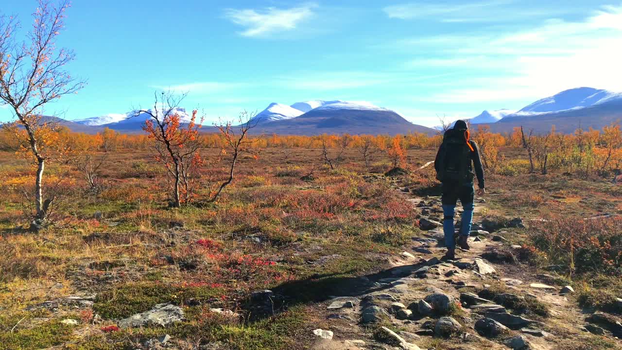 abisko 국립 공원의 하이커는 카메라에서 멀리 걸어서 아름다운 경치 좋은 가을 알파인 풍경으로 멀리 눈으로  ⁇ 인 산과 함께