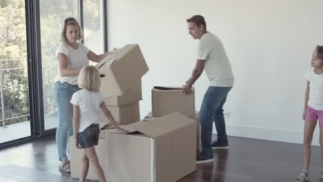 happy parents and two girls moving into new flat