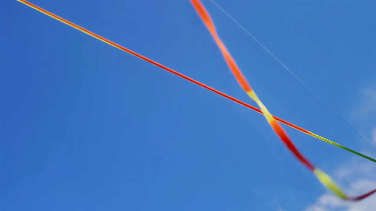 Nastro colorato che danza nel vento contro un cielo azzurro limpido