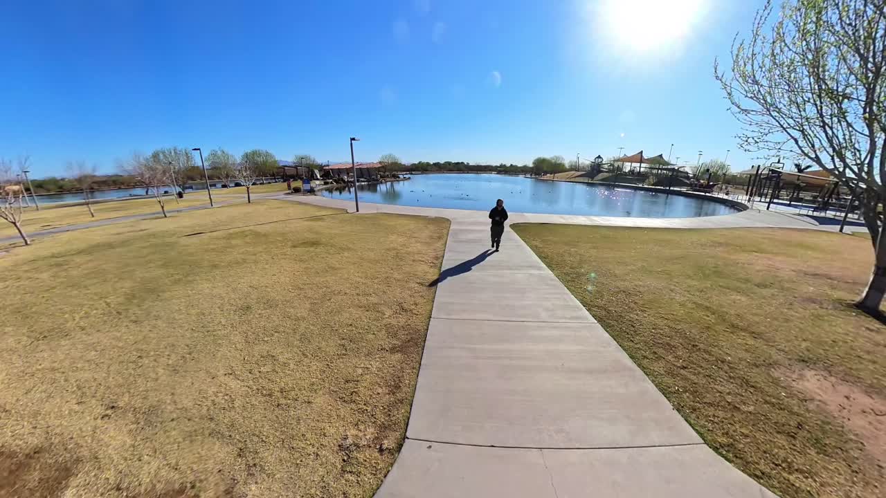 Static Red haired male walking by a lake in Mansel Crater Park in Queen Creek Arizona.