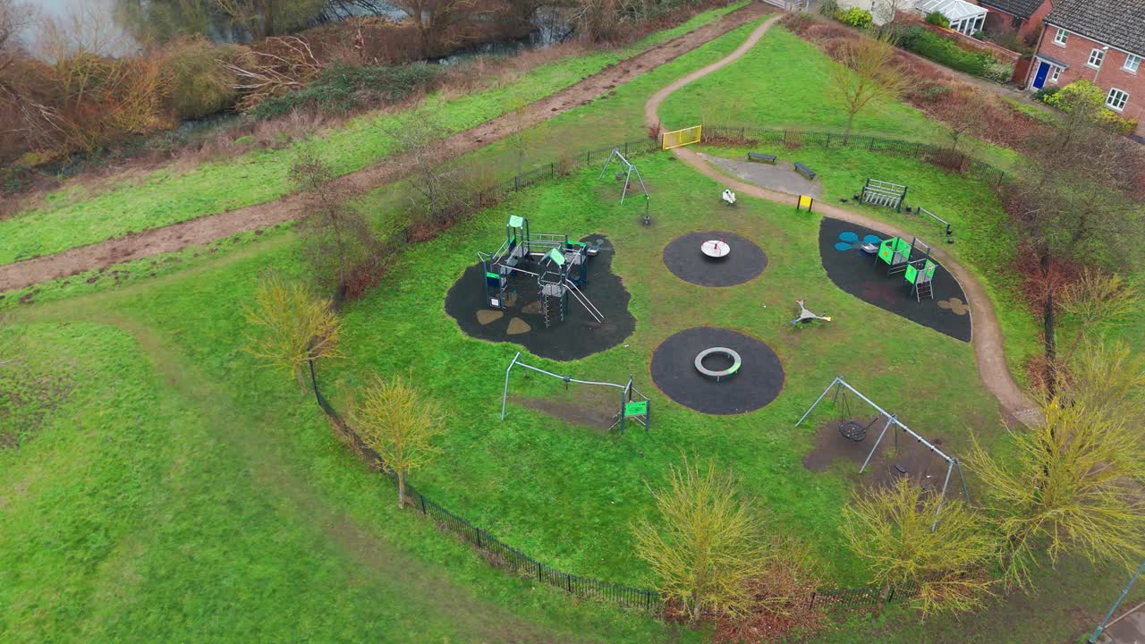 A playground in bury st edmunds with trees and green grass, aerial view