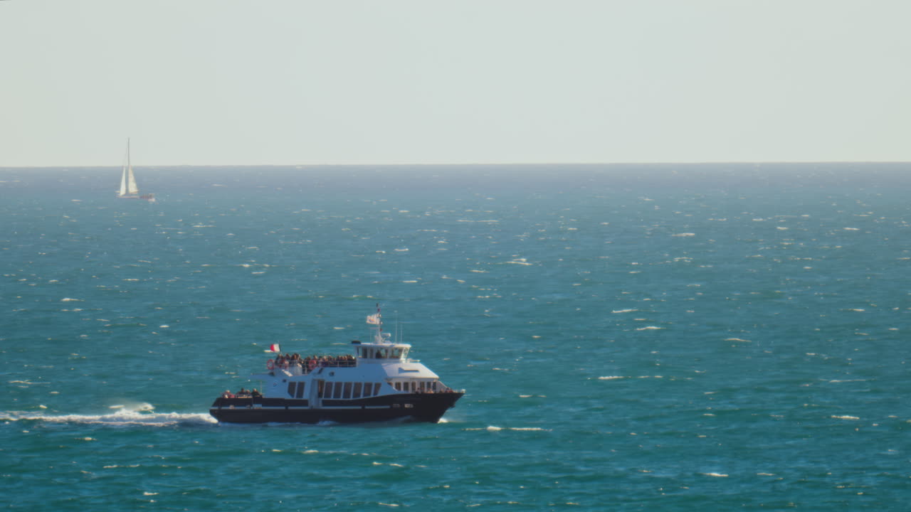 Boat filled with people moving on the sea on a sunny day