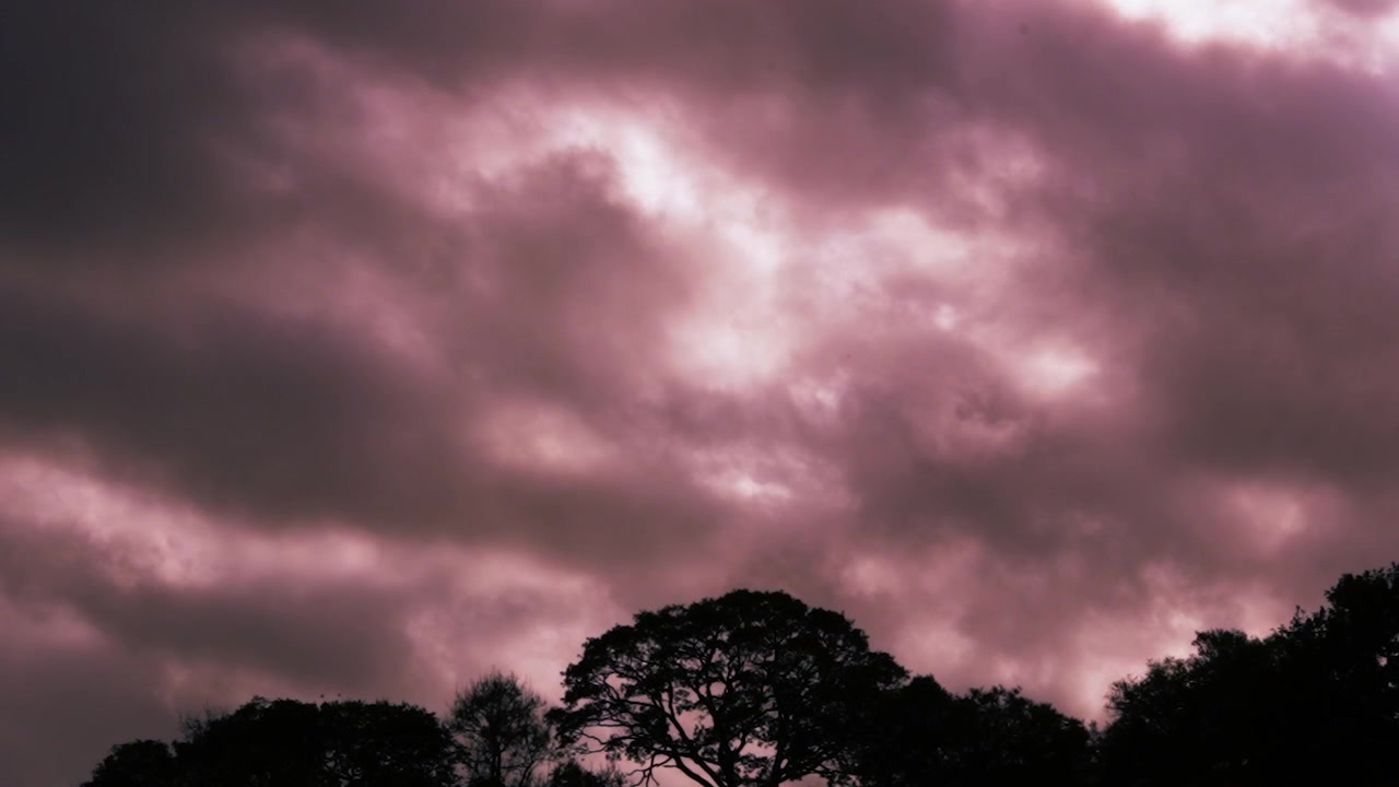 Dark Clouds Time Lapse with Ominous Red Apocalyptic Hell Colors with Sun Rays Above Tree Silhouettes 4K