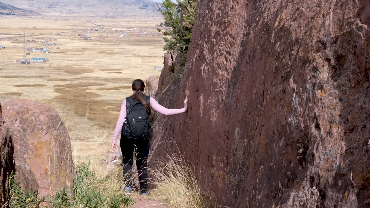 Follow a young woman as she explores a trail at the mystical Aramu Muru Portal archaeological site in Peru