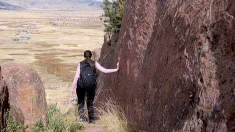 follow a young woman as she explores a trail at the mystical aramu muru portal archaeological site in peru