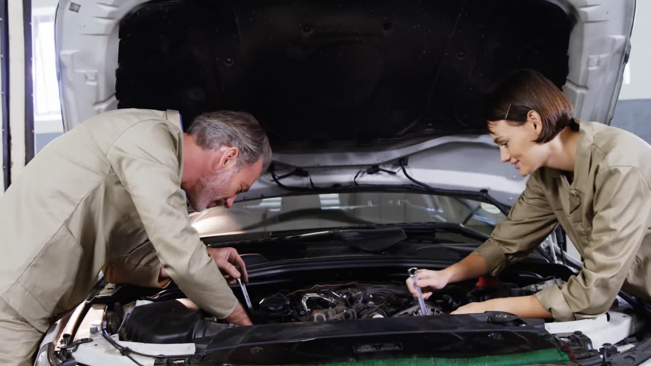 equipo de mecánicos que atienden un motor de automóvil